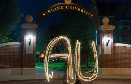 AU spelled out with sparkler in front of arch