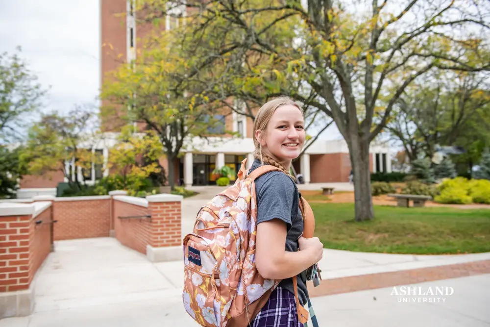 student walking in front of the library