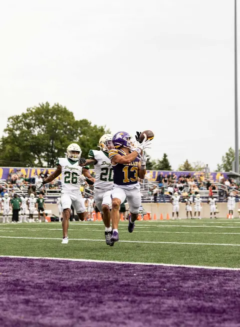 AU football player catching football