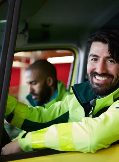 Firefighters in cab of a fire truck.