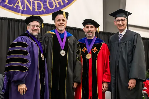 President Jon Parrish Peede, Trustees' Distinguished Professor Mitch Metzger, Provost Greg McBrayer and AU Board of Trustees Chair Jim Hess pose at 2025 commencement ceremony.