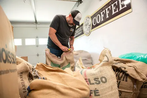 Doug Cooper '85 opens up a bag of coffee beans.