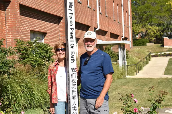 John Lersch ’79 (right) poses with the Peace Pole