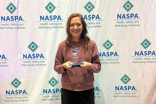 Janel Molnar with Outstanding Peer Education Advisor award at NASPA conference