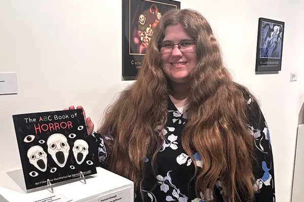 Hanna Keough poses with her award-winning "The ABC Book of Horror" work