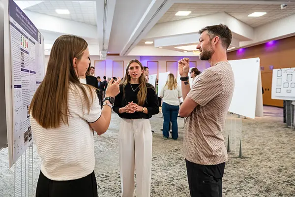 Professor Chris Chartier speaking with students at the 2026 URCA Symposium