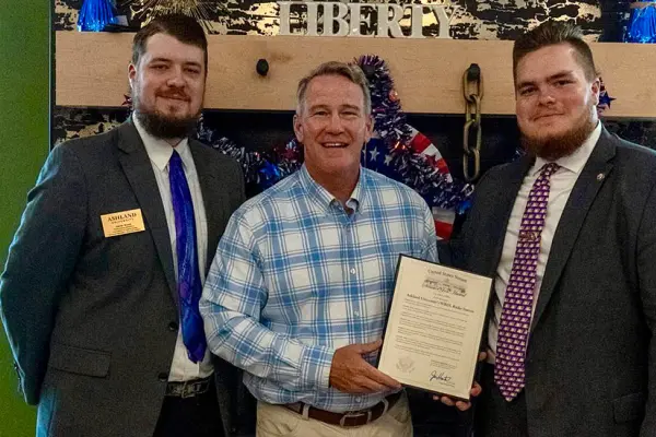 Derek Wood, Sen. Jon Husted and Aidan Haggard pose with the official commendation