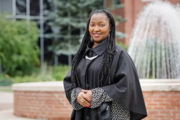 Rosaire Ifedi in graduation gown in front of fountain