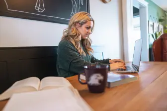 Student working on a laptop while sitting in a coffee shop