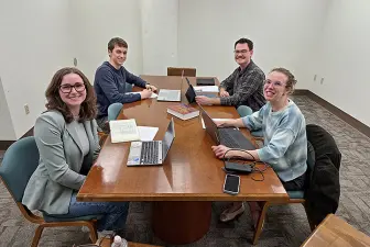 three students, professor presenting virtually