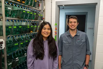 Leap Vathanak and Luke Bowen pose next to zebrafish