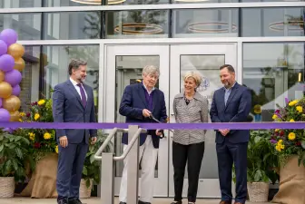 Dwight Schar cuts the ribbon in front of Amstutz Hall during the Schar Plaza dedication