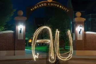 AU spelled out with sparkler in front of arch