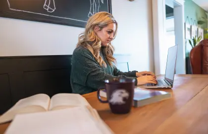 Student working on a laptop while sitting in a coffee shop