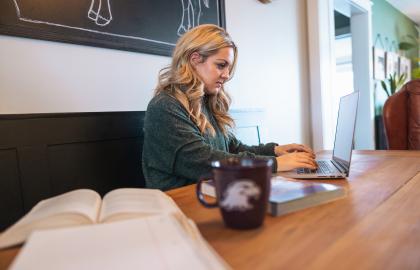 Student working on a laptop while sitting in a coffee shop