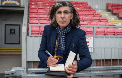 character from Ted Lasso wearing AU T-shirt