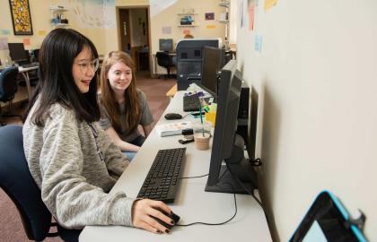 Two female students sitting at a computer station