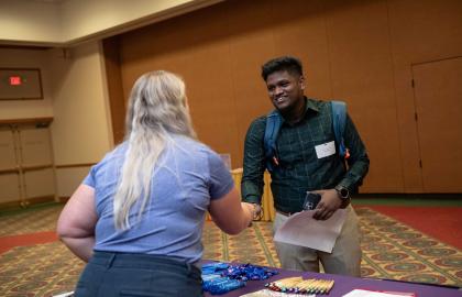 Student shaking hands with recruiter at job fair