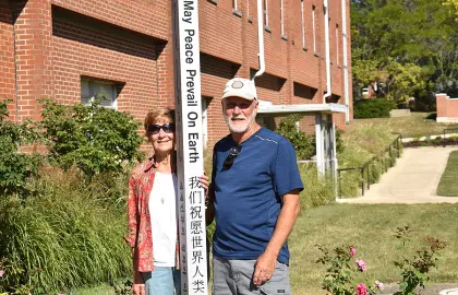 John Lersch ’79 (right) poses with the Peace Pole