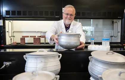 Professor Jeff Weidenhamer shows the aluminum cookware he has been using for research on lead poisoning. 