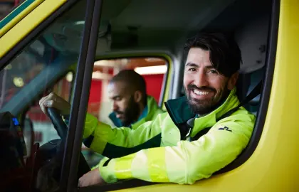 Firefighters in cab of a fire truck.