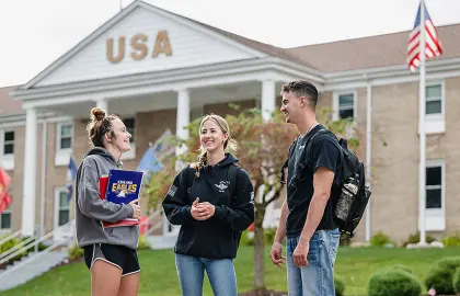 A group of military-connected students talking outside the USA House