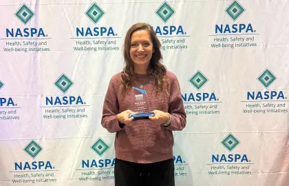 Janel Molnar with Outstanding Peer Education Advisor award at NASPA conference