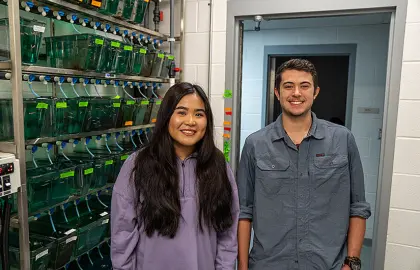 Leap Vathanak and Luke Bowen pose next to zebrafish