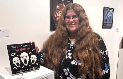 Hanna Keough poses with her award-winning "The ABC Book of Horror" work