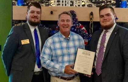 Derek Wood, Sen. Jon Husted and Aidan Haggard pose with the official commendation