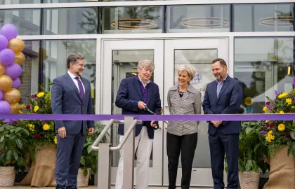 Dwight Schar cuts the ribbon in front of Amstutz Hall during the Schar Plaza dedication