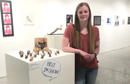 student displaying artwork