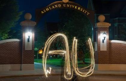 AU spelled out with sparkler in front of arch