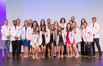 AU’s physician assistant students on stage in their white coats