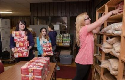 Members of Social Work Club help stock shelves at Associated Charities 
