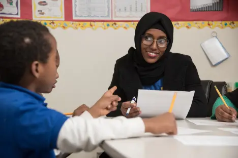 Student teacher working in classroom with students