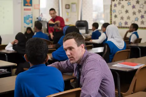 Student teacher talking with a student in the classroom