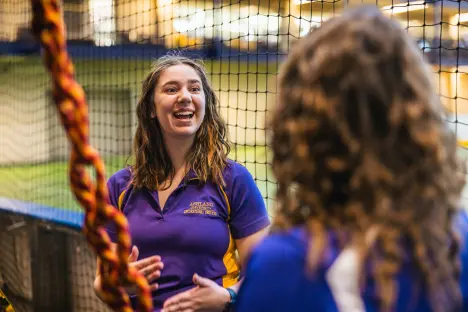 Climbing wall instructor talks with students about to climb