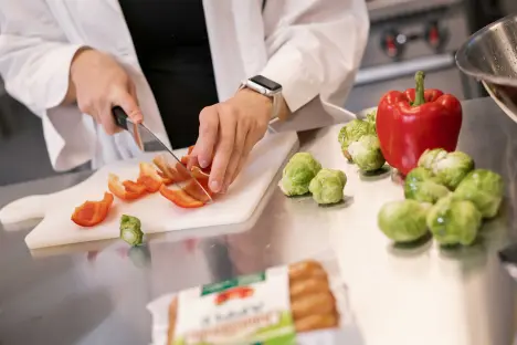 student cutting vegetables in food lab