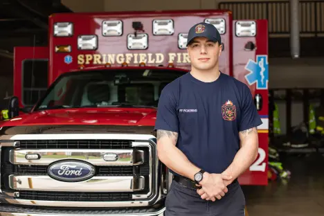 Paramedic Travis Pickering standing in front of truck 