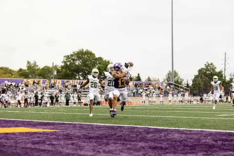 AU football player catching football
