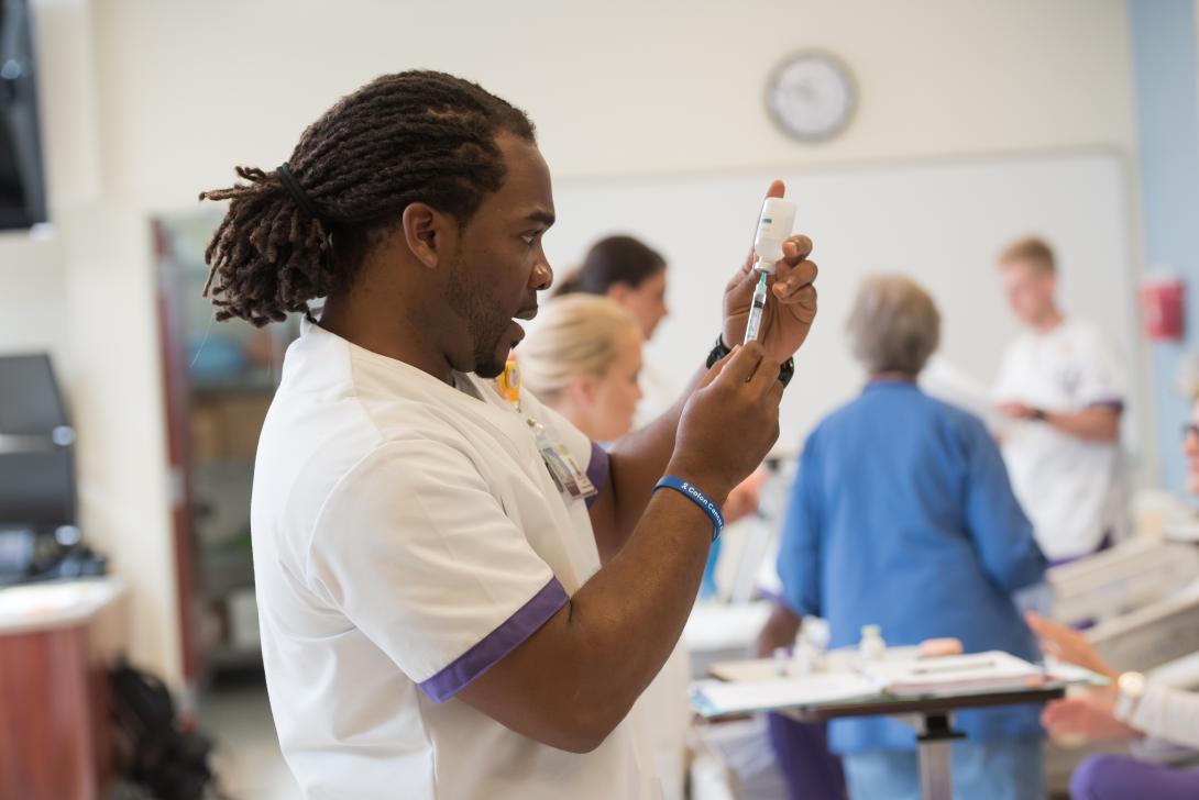 Male nursing student prepares a syringe