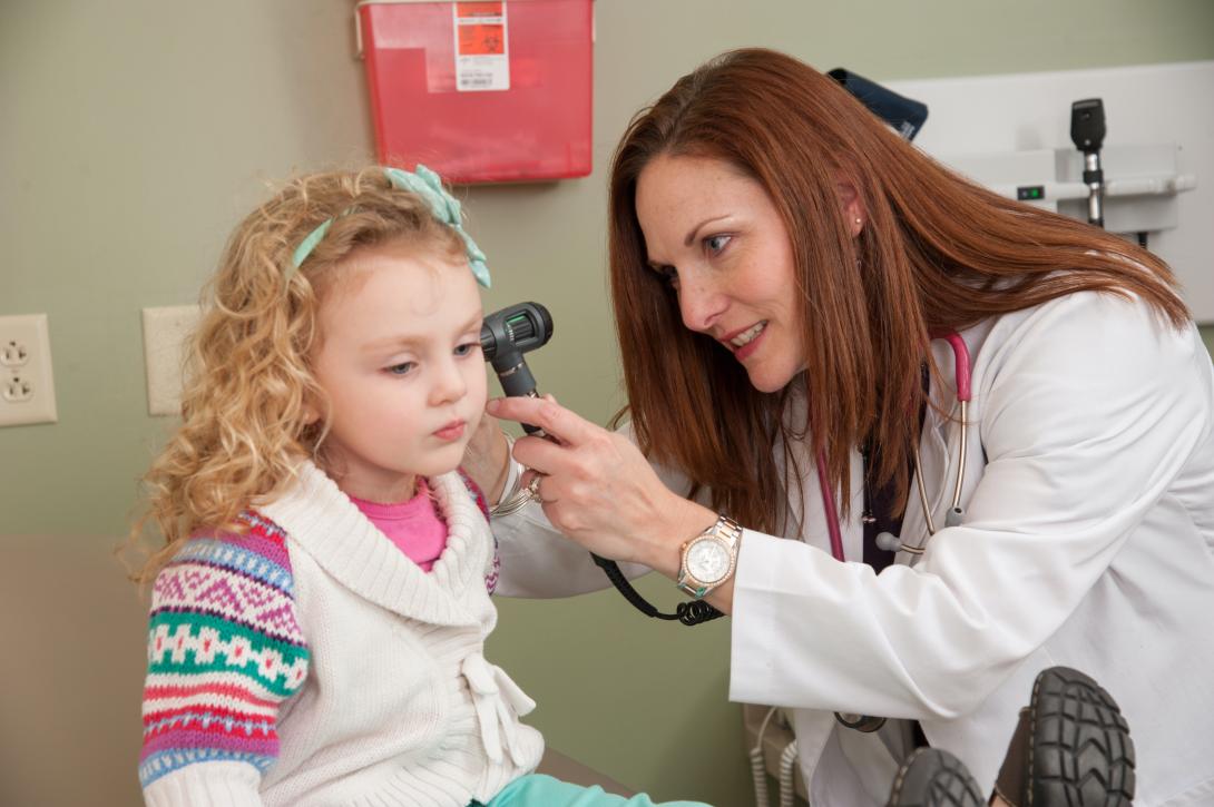 Nursing student examines the ears of a child