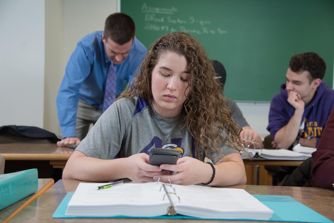 Student in math class using a calculator