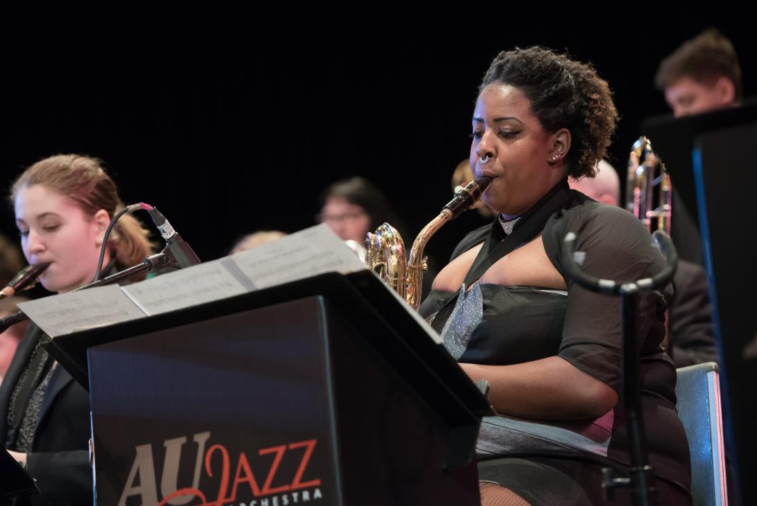 Member of the AU Jazz band playing the saxophone in concert
