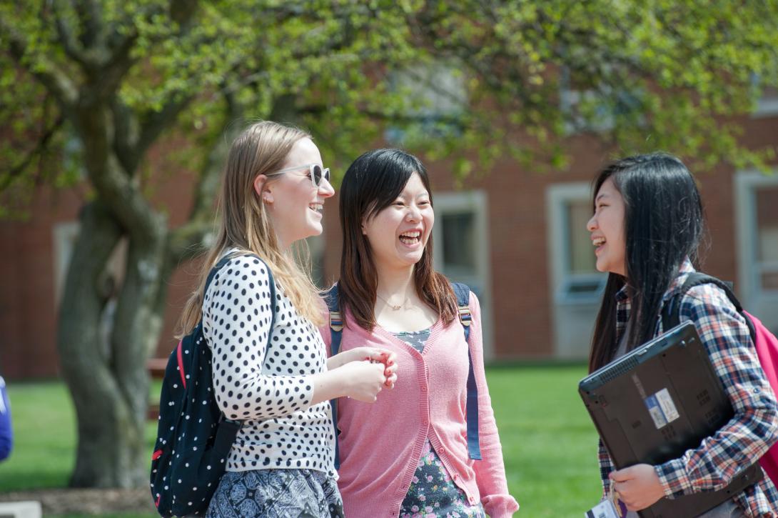 Three female students, outside, laughing