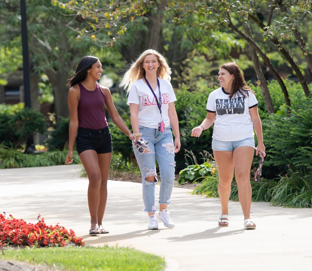 Three female students walking on campus during Festival on Founders