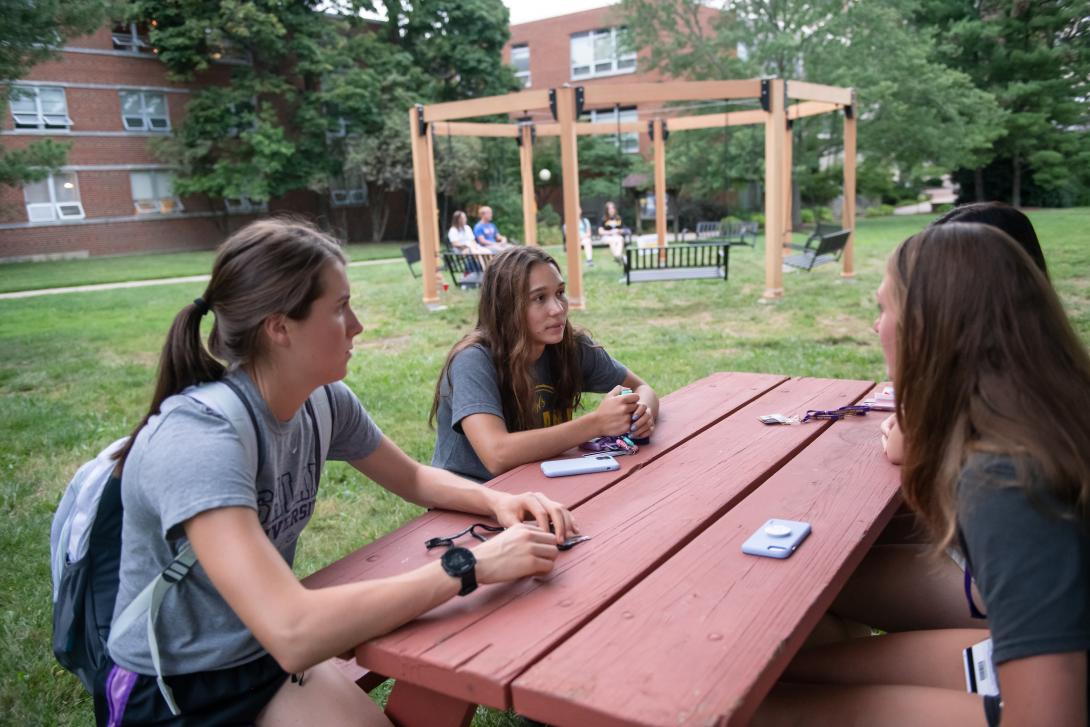 Honors students at ice cream social sitting at picnic table