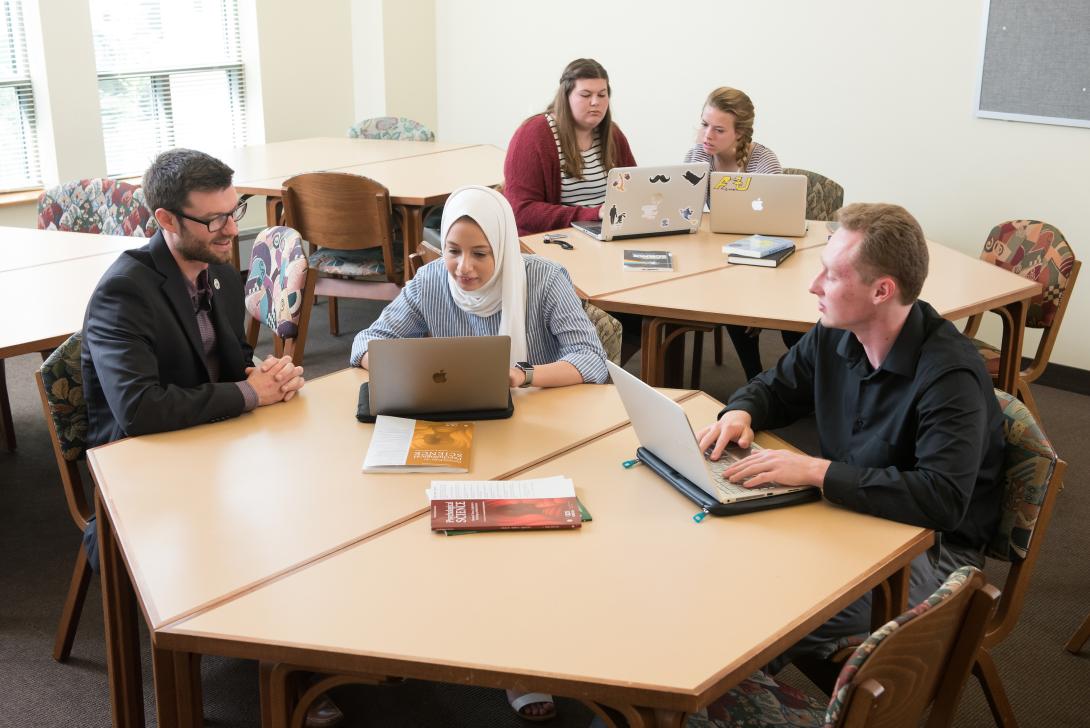 Students and faculty sitting around table in Psychology Research Center