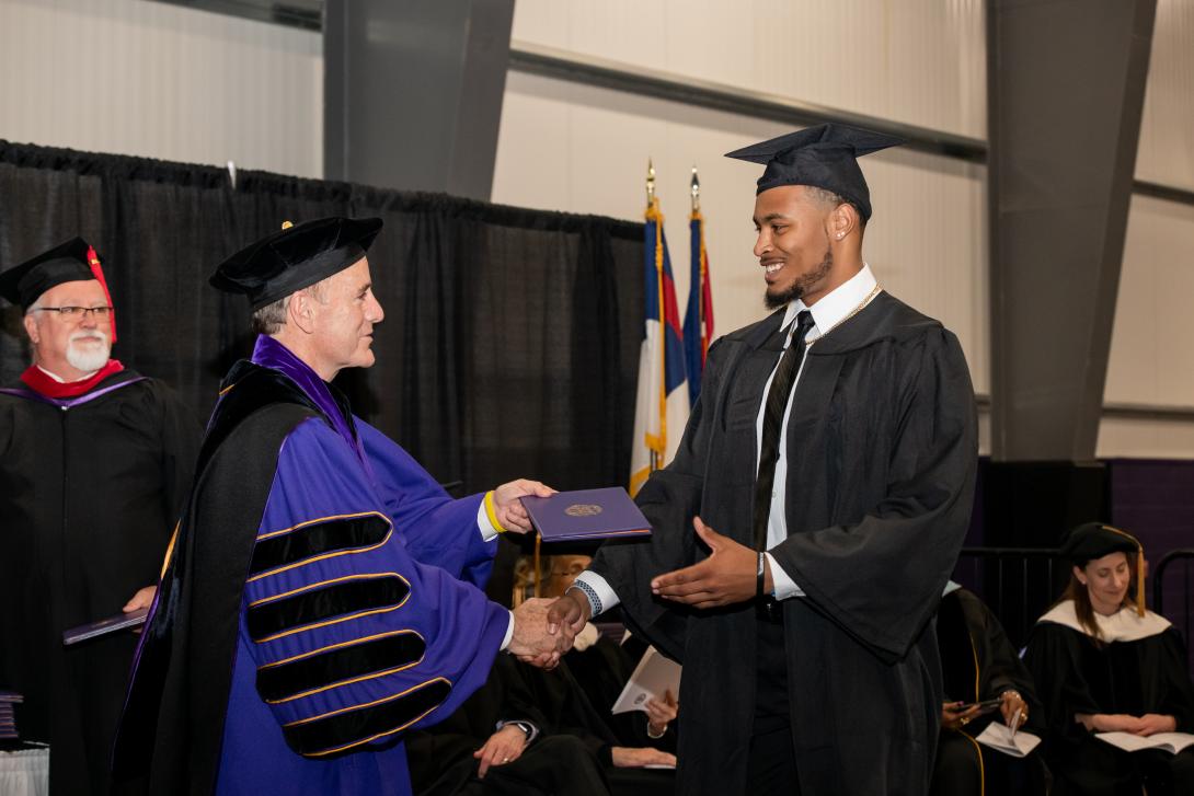 graduate receiving his diploma